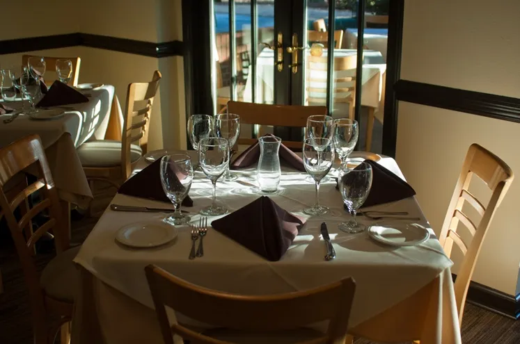The dining room set for dinner, with French doors open to the patio